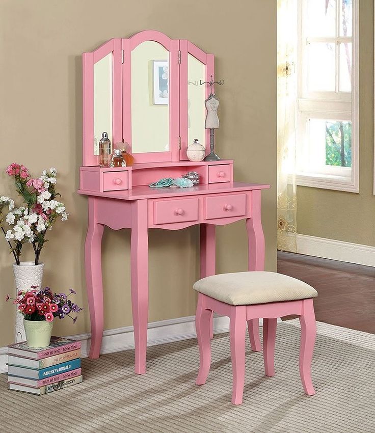 a pink dressing table with mirror and stool