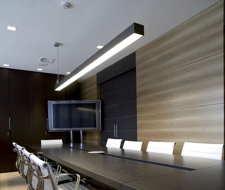 an empty conference room with a flat screen tv on the wall and chairs in front of it