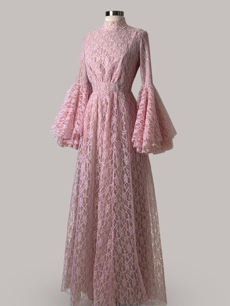 Revel in the romantic allure of this Anna Augusta Evening Maxi Dress, designed in a delicate pink lace that conjures visions of elegance and femininity. This pre-worn size 8 gown is in perfect condition, featuring a full-length lace overlay that provides a stunning visual texture. The dress is accented with dramatic bell sleeves and a cinched waist, enhancing the silhouette and providing a timeless charm ideal for formal occasions, elegant receptions, and bridal parties. Pristine Condition: Carefully preserved to maintain a flawless appearance. Delicate Pink Lace: Soft and feminine, perfect for elegant affairs. Dramatic Bell Sleeves: Add a touch of vintage elegance and dramatic flair. Flattering Cinched Waist: Highlights the silhouette beautifully. Suitable for Various Formal Events: Ideal Maxi Evening Dress, Bridal Cape, Visual Texture, Bridal Parties, Maxi Dress Evening, Lace Maxi, Lace Overlay, Cinched Waist, Ball Dresses