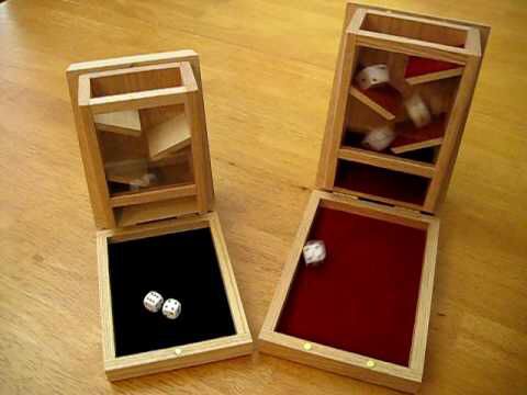 two wooden boxes with dices in them on a table