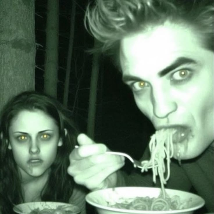 a man and woman eating noodles from bowls in the dark with their eyes glowing yellow