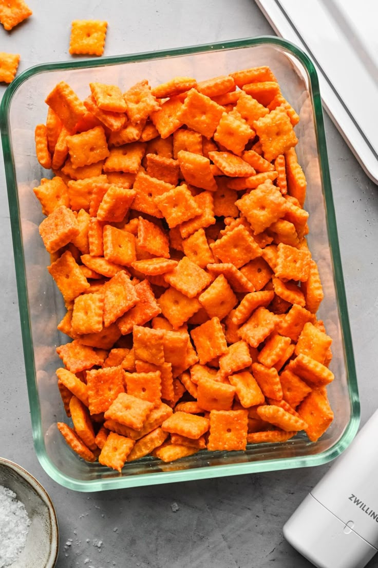 a glass casserole dish filled with cheesy tater tots next to an electric blender