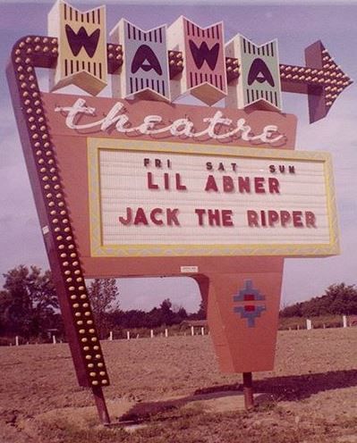 an old theater sign in the middle of nowhere