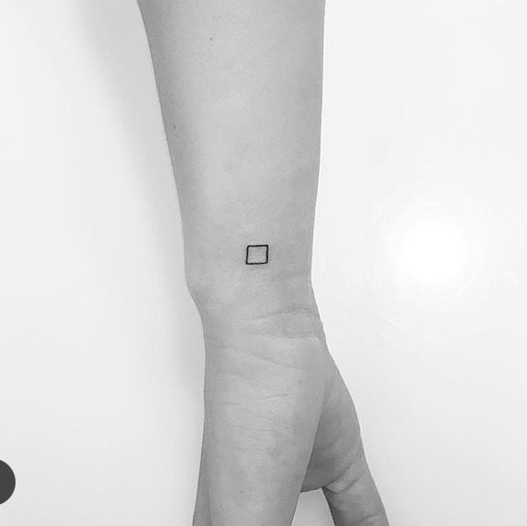 a person's arm with a small square tattoo on it