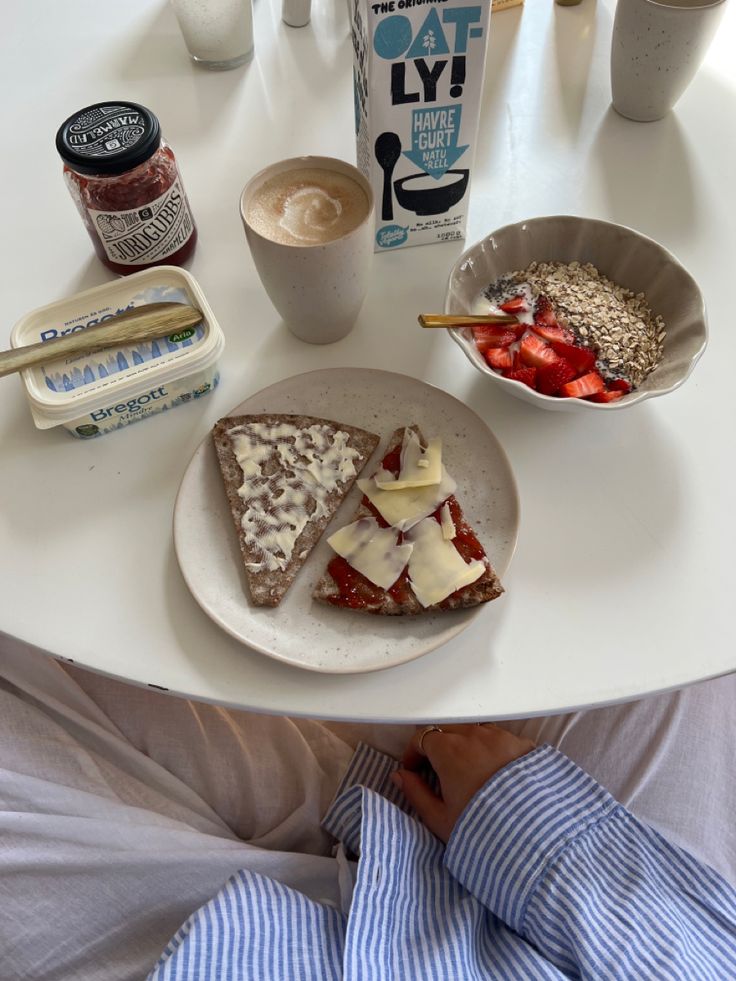 a person sitting at a table with some food on it and milk in the background