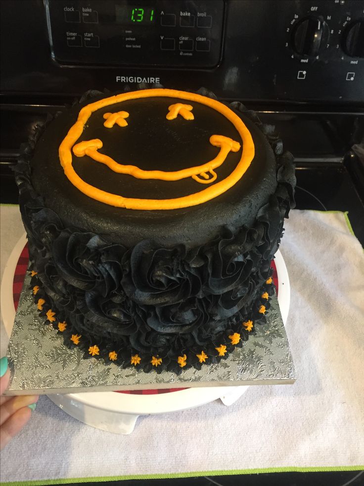 a black and yellow cake sitting on top of a table next to a microwave oven