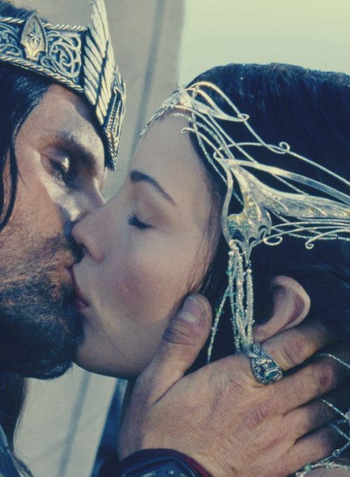 a man and woman kissing each other while wearing headdresses on their heads