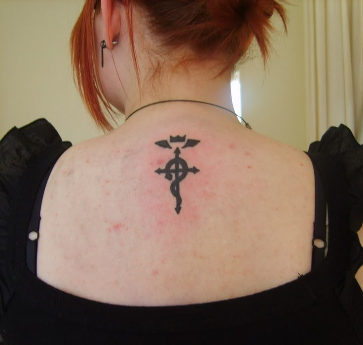 a woman with a cross tattoo on her back