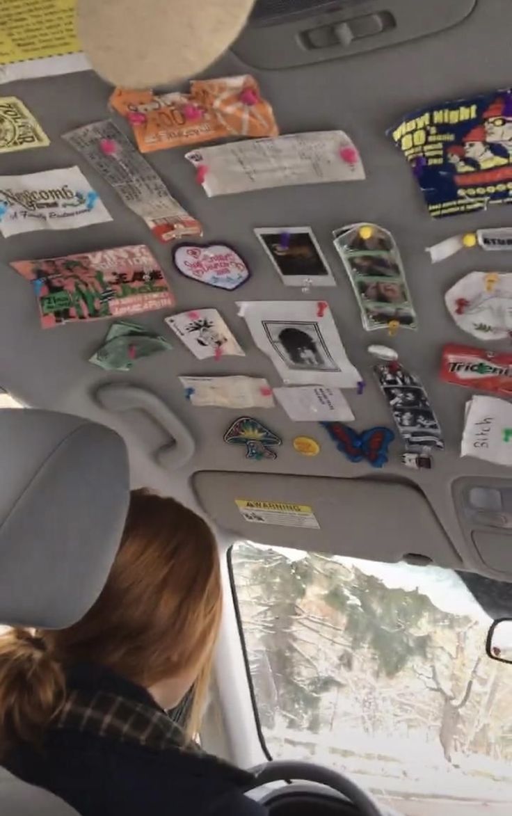 a woman sitting in the back seat of a car with lots of stickers on it