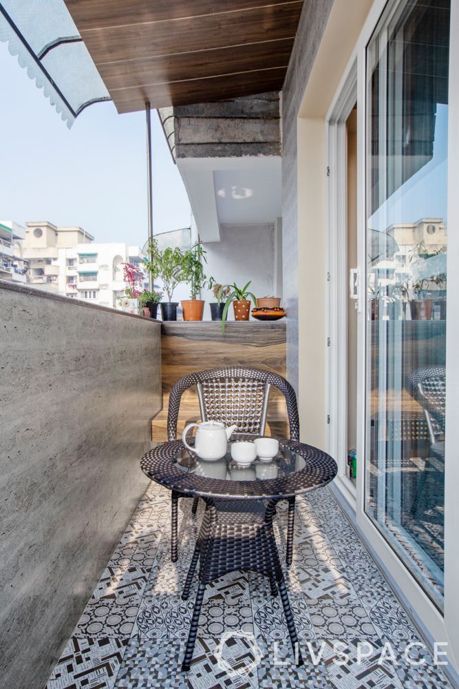 an outdoor table with two cups on it next to a patio area that has potted plants