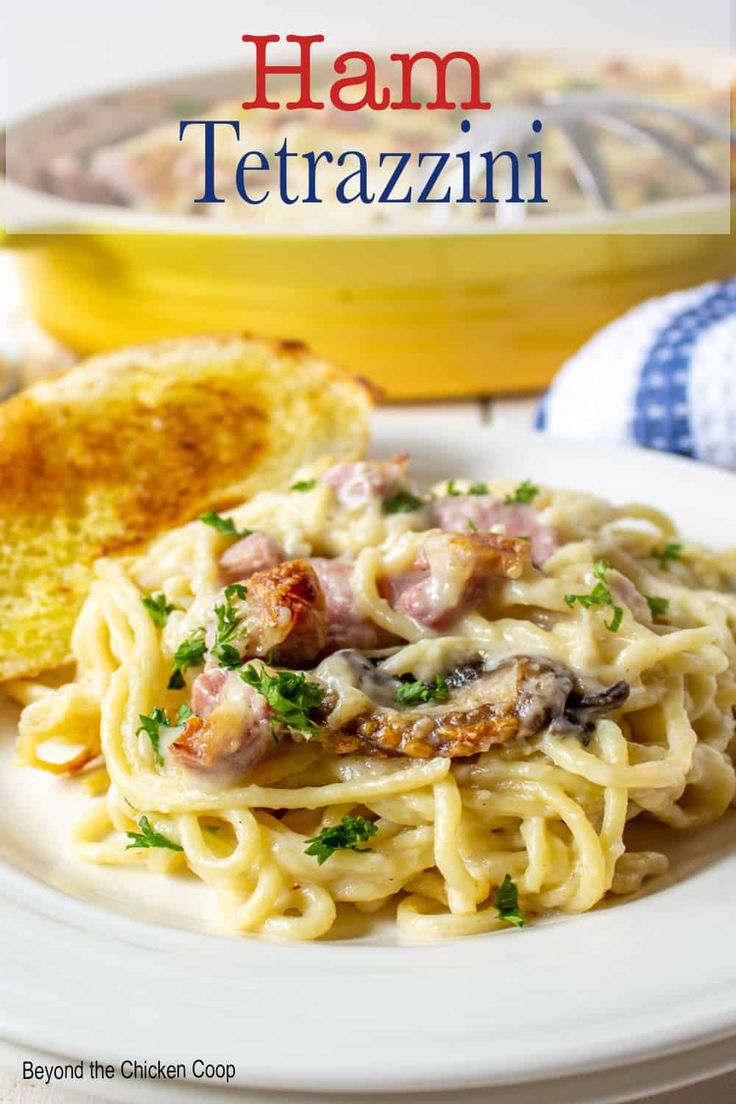 ham tetrazzini on a white plate with garlic bread and parsley in the background