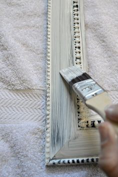 a person is using a brush to paint the edge of a piece of fabric