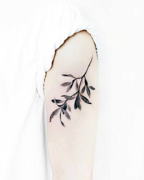 a black and white photo of a branch tattoo on the left side of the arm