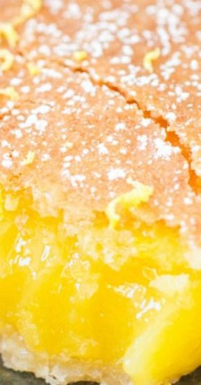 a close up of a piece of cake with powdered sugar and lemon on top