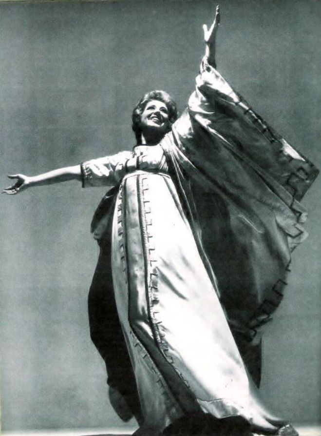 an old photo of a woman dressed in costume and holding her arms out to the side