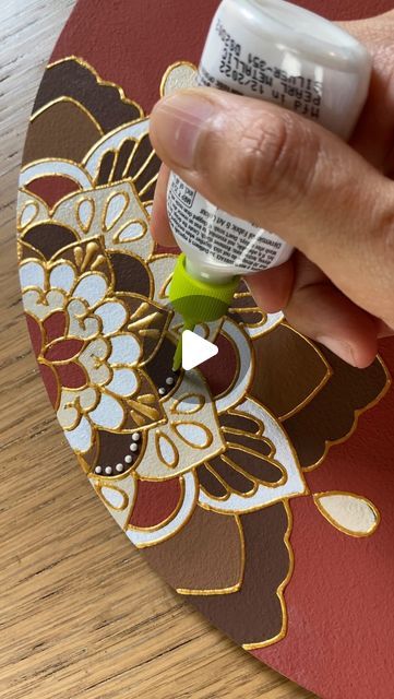 a person is painting a flower on a piece of paper