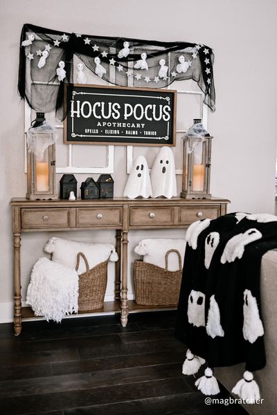 a room decorated for halloween with ghost decorations on the wall and black and white decor