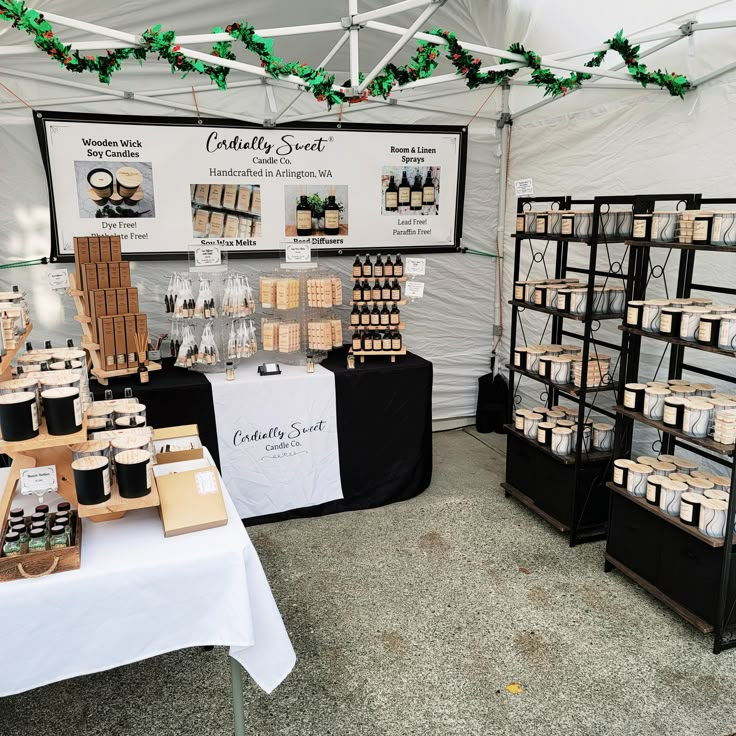 a table that has some items on it in front of a white and black tent