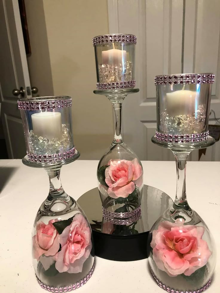 three glass vases with pink roses in them on a table next to each other