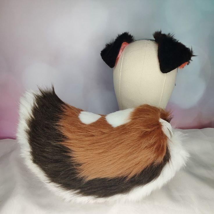 a stuffed animal that is laying down on a bed with its head turned to the side