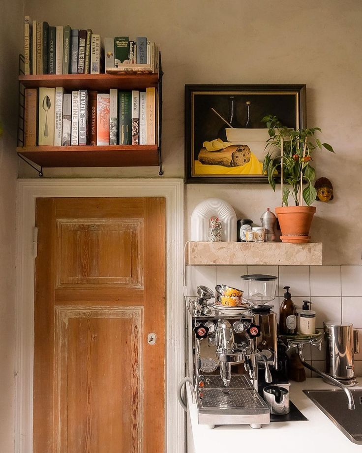 a coffee machine sitting on top of a kitchen counter next to a sink and bookshelf