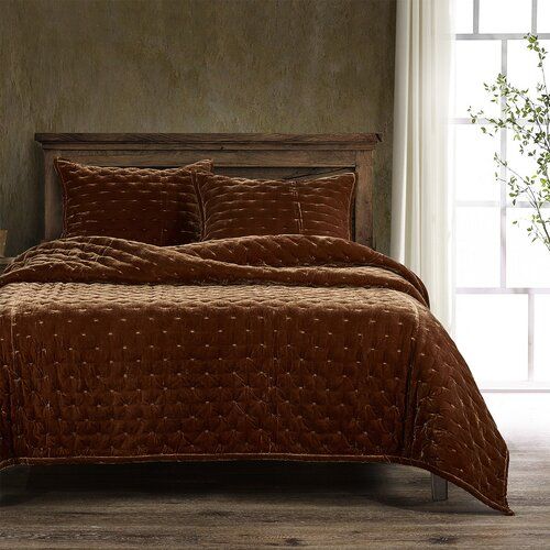 a bed in a room with a wooden headboard and brown bedspread on it