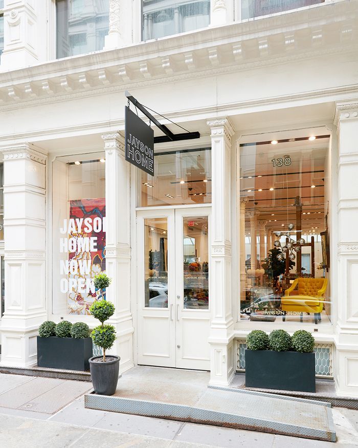 a store front with two planters in front of it and a sign on the door