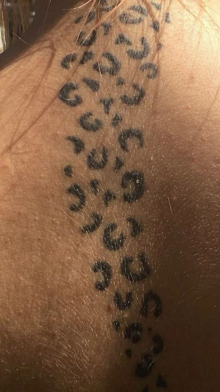 the back of a woman's neck with black and white animal print on it