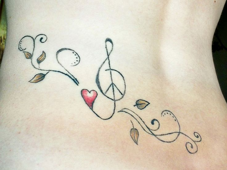 a woman's lower back tattoo with musical notes and a heart