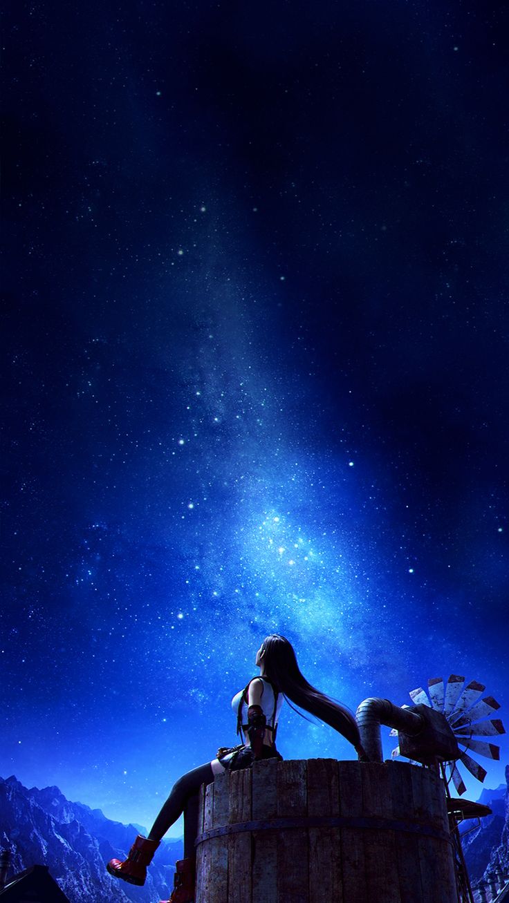 a woman sitting on top of a wooden structure under the stars