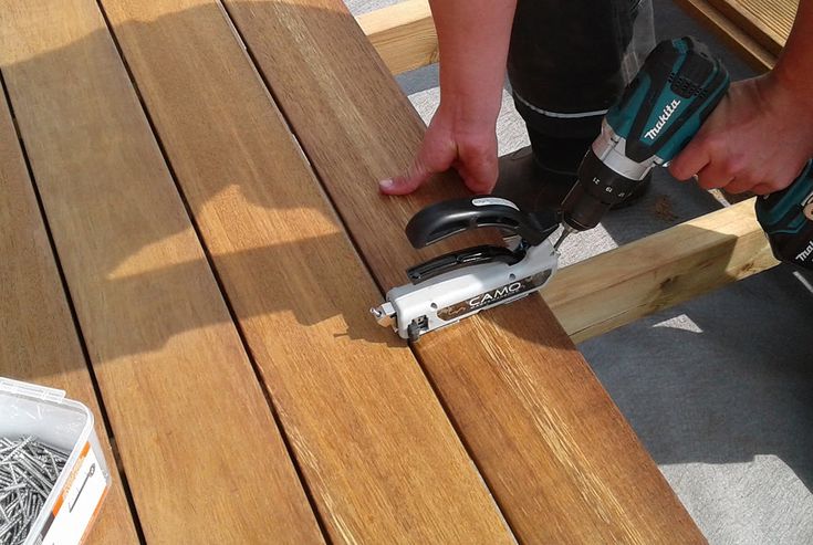 a person using a power drill on a wooden table