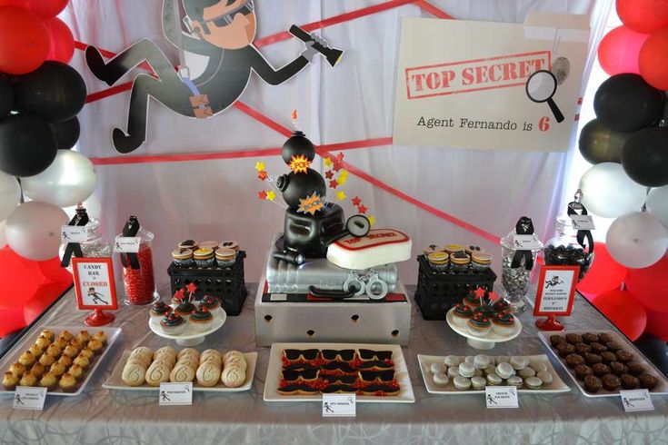 a table topped with lots of desserts and balloons in the shape of an engine