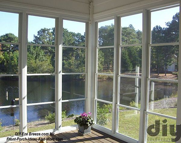 an open room with large windows overlooking a lake and trees in the backgroud