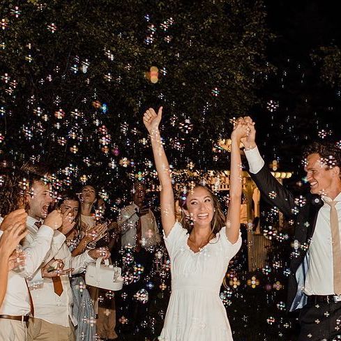 a group of people are throwing bubbles in the air