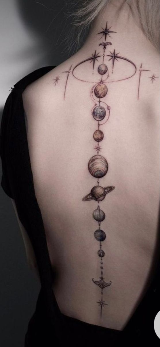 the back of a woman's neck with planets and stars on it