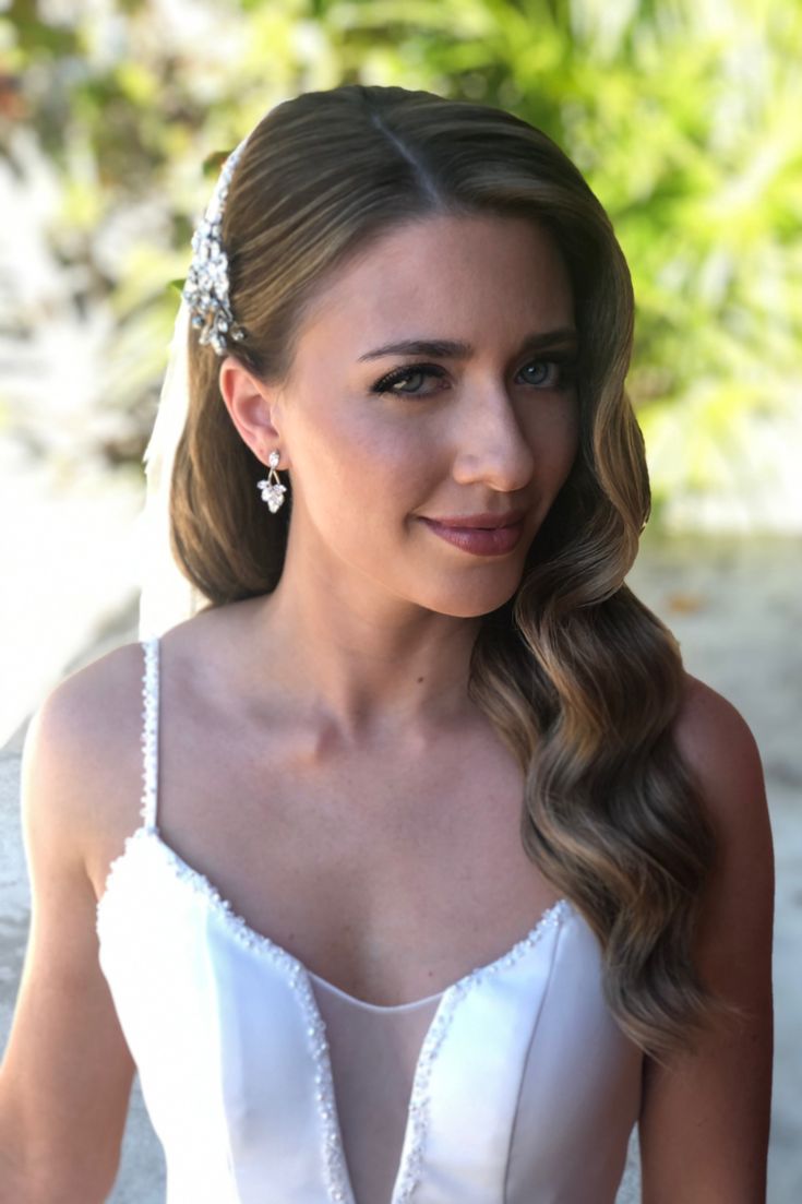 a woman with long hair wearing a white dress and holding a flower in her hand