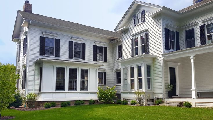 a large white house with black shutters on the windows