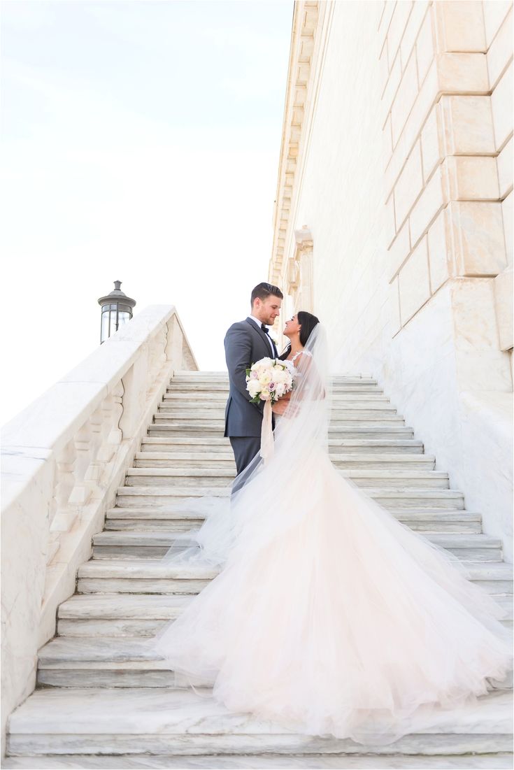 a bride and groom kissing on the steps