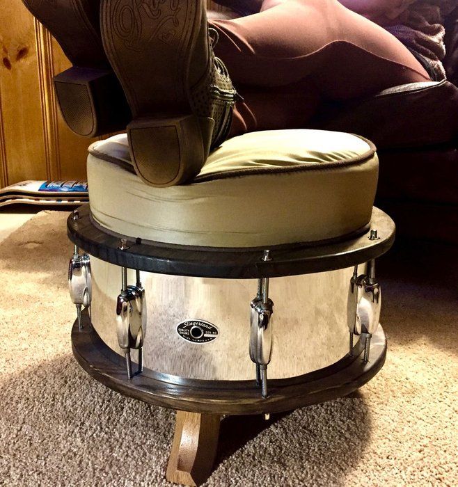 a drum set sitting on top of a round table in front of a couch and chair