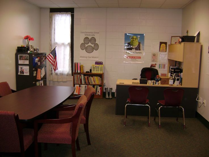 an office with desks, chairs and bookshelves on the walls is shown