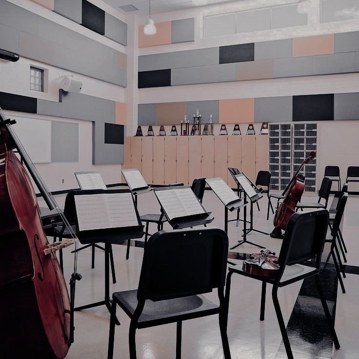 an empty room filled with lots of chairs and musical instruments on the tables in front of them