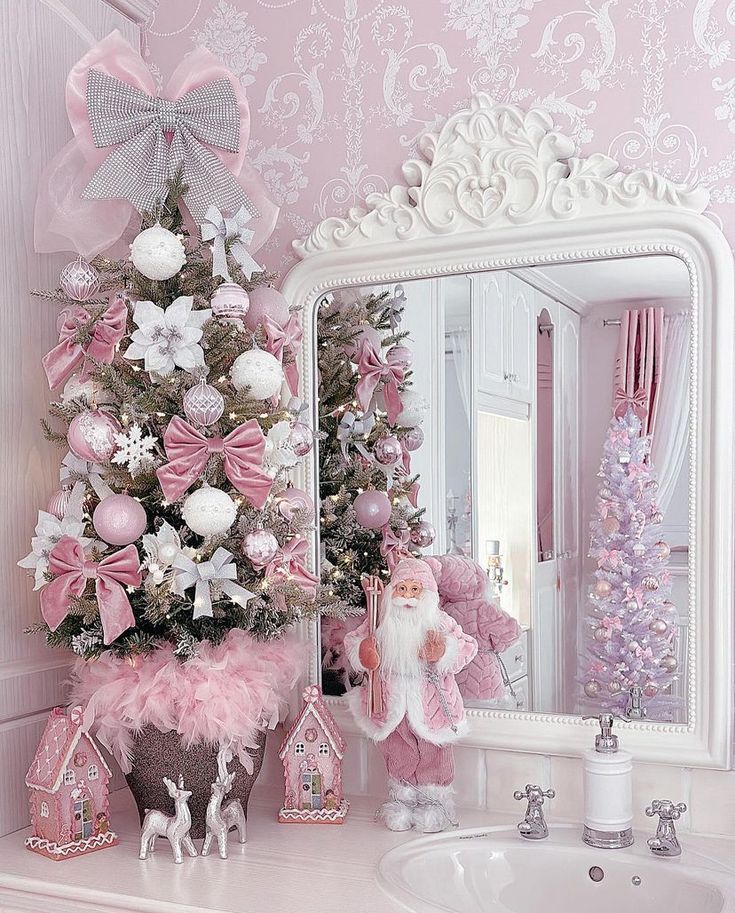 a pink christmas tree decorated with white and pink ornaments in a powder room next to a mirror