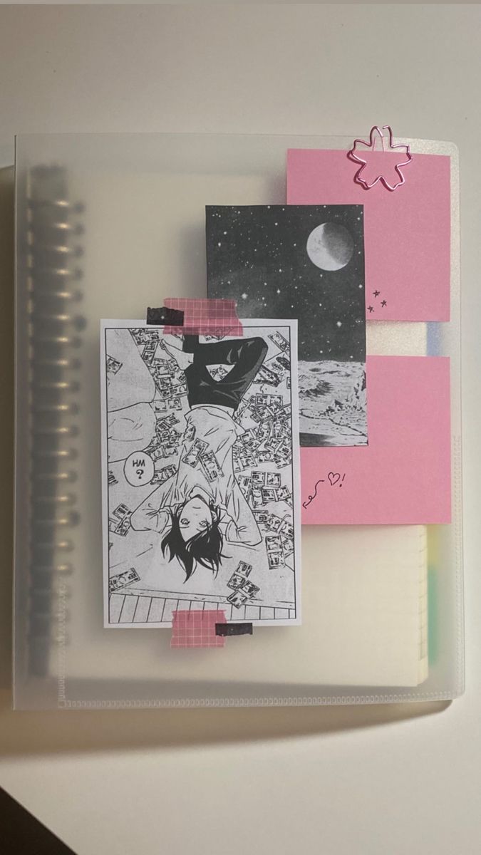 an open notebook with pictures and writing on the pages next to a spiral bound notepad