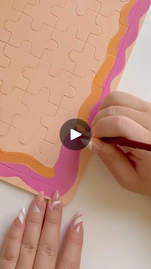 a woman is making a puzzle out of paper and glues it with her hands