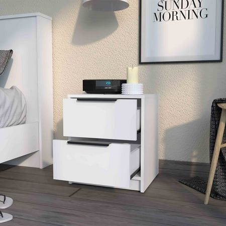 a white night stand next to a bed