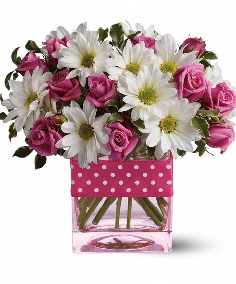 pink roses and white daisies in a square vase with polka dot trimmings