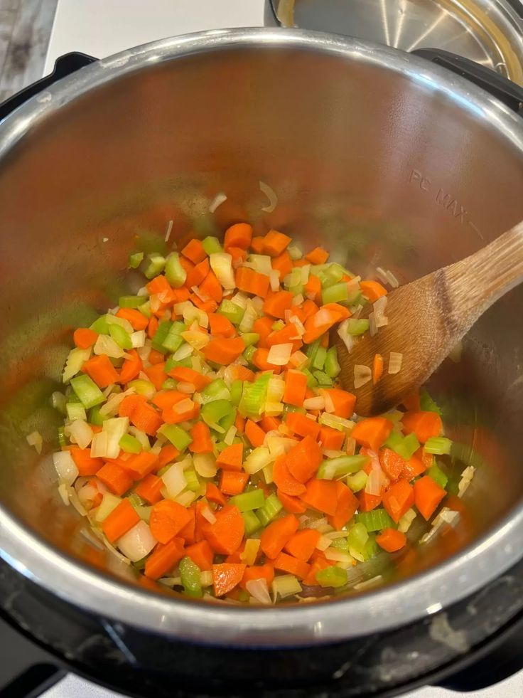 carrots, celery and onions are cooking in the pot on the stove