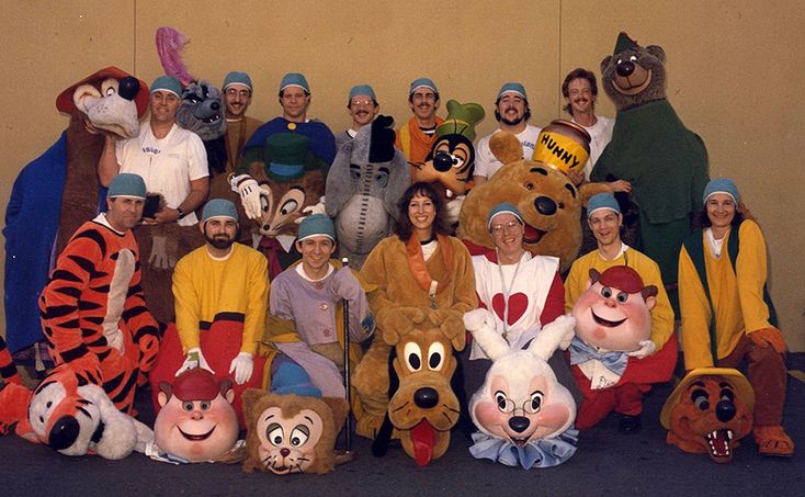 a group of people dressed in costumes posing for a photo with winnie the pooh