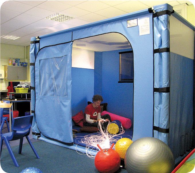 a person sitting on a couch in a room with blue walls and balls around it