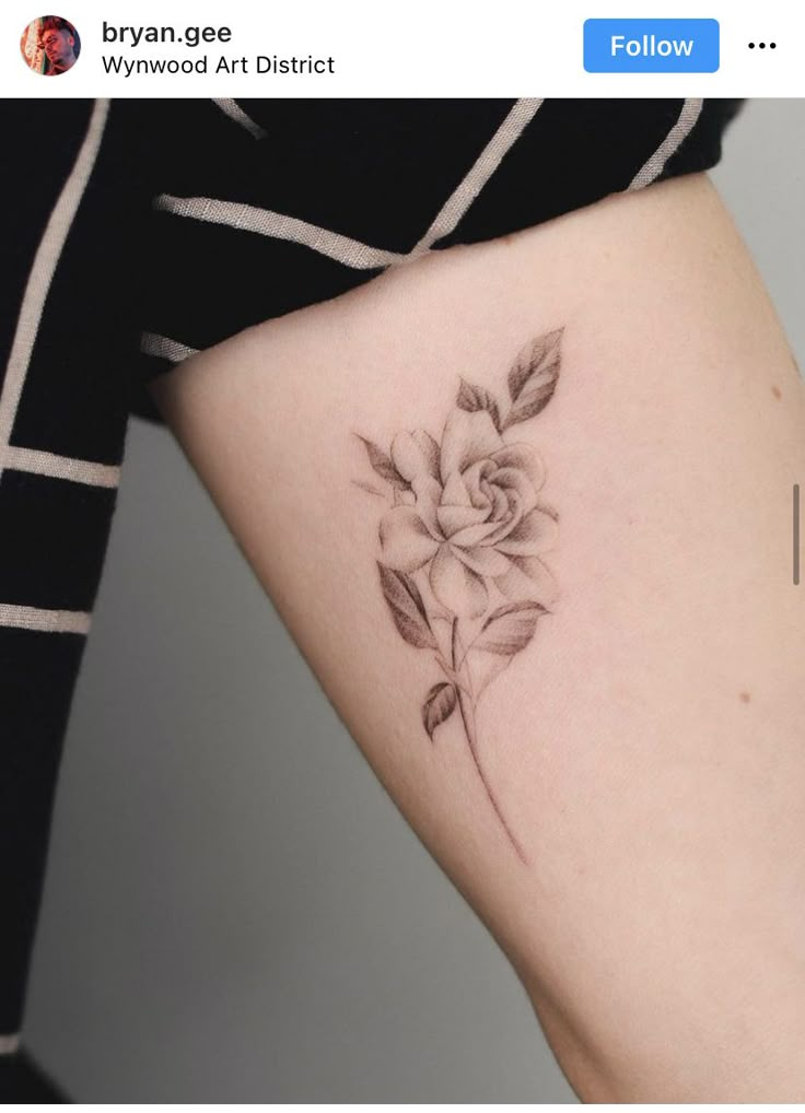 a woman's arm with a rose tattoo on the left side of her body